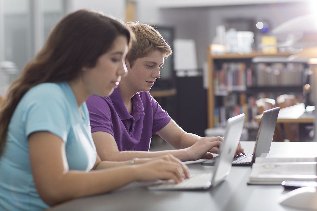 A mentor and student reviewing machine learning concepts together on a laptop
