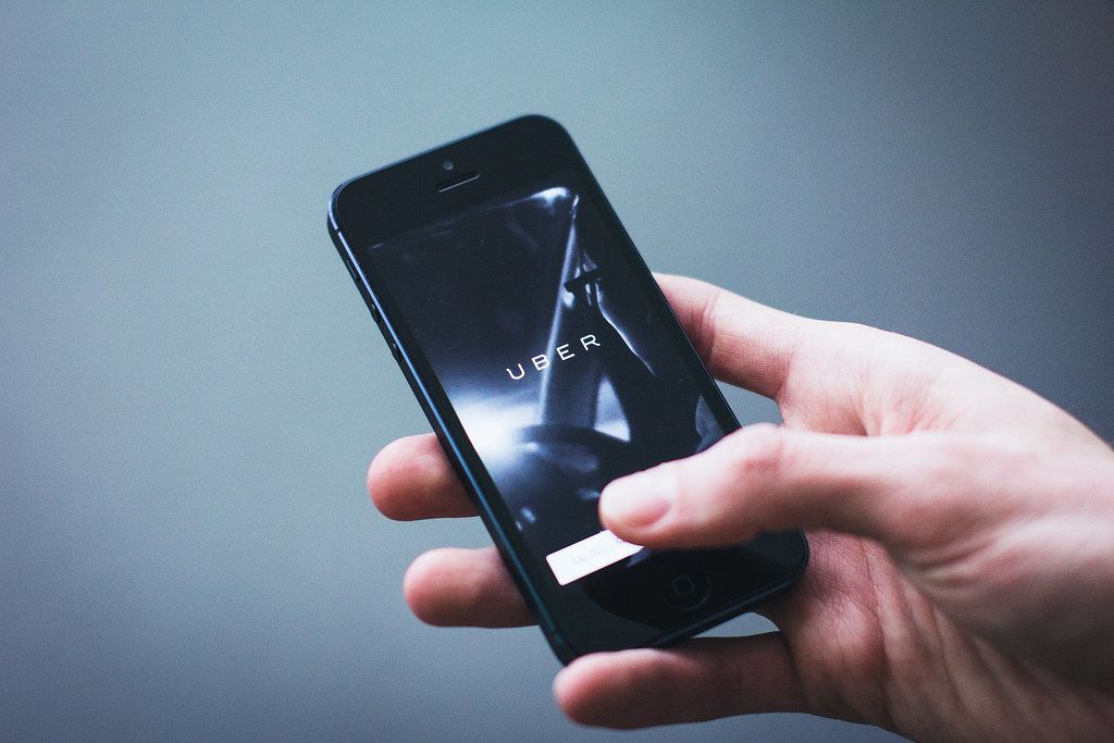 A hand holding a smartphone with a mobile app open